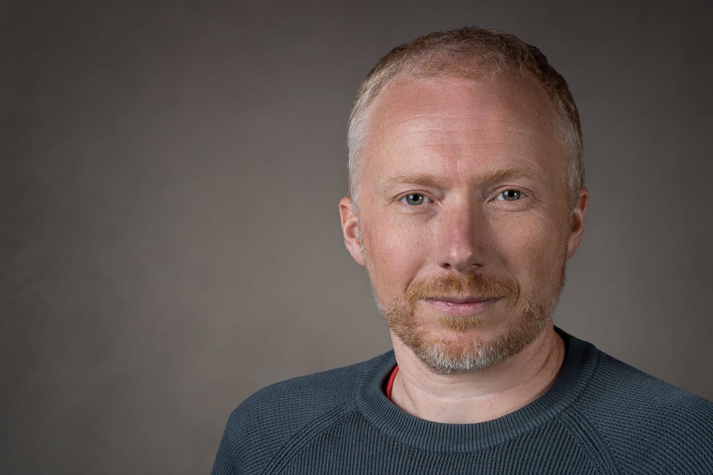 Professional studio headshot against a neutral background