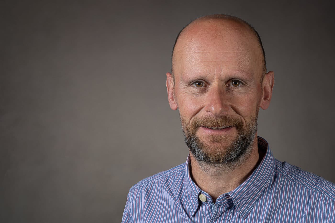 Professional studio headshot against a neutral background