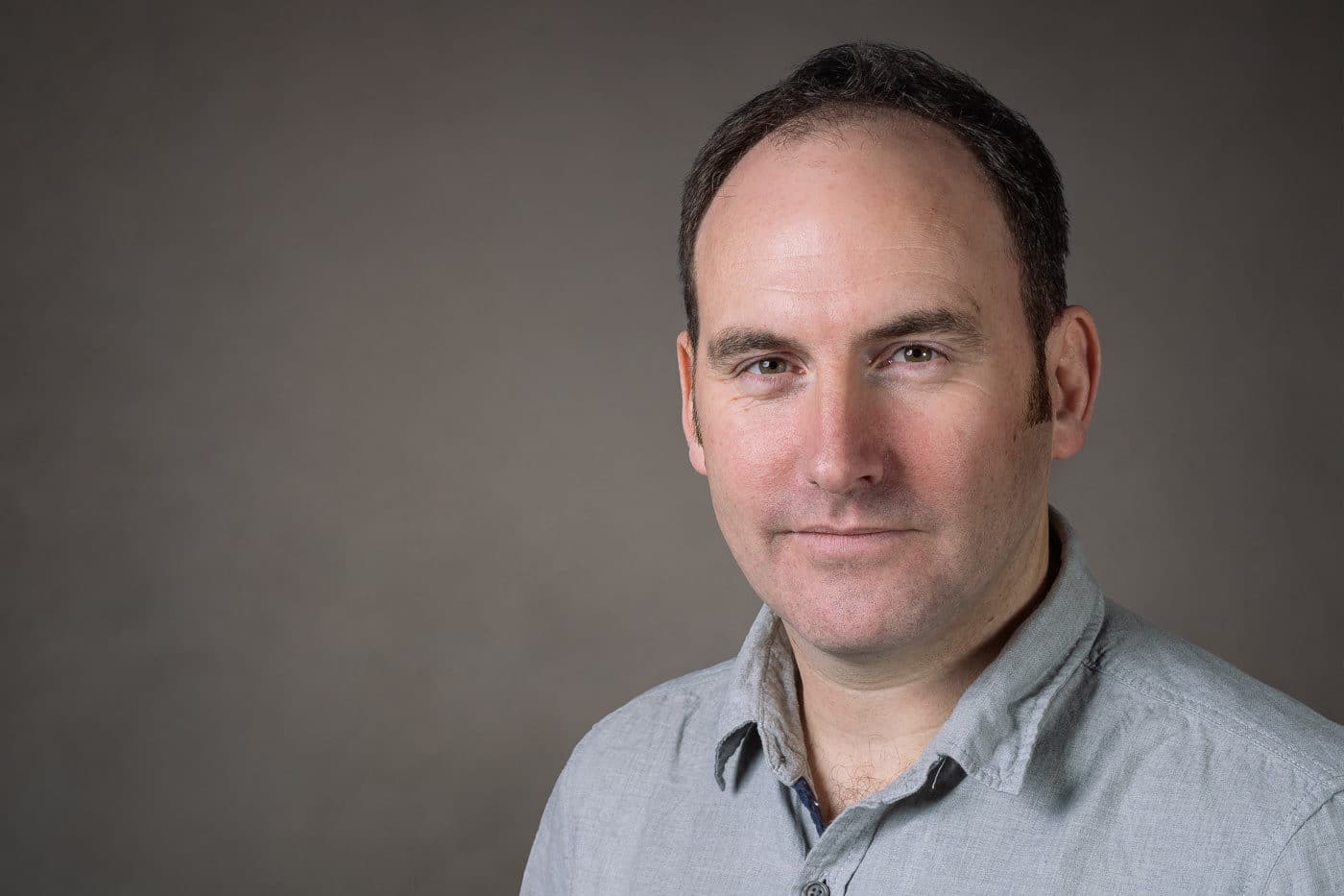 Professional studio headshot against a neutral background