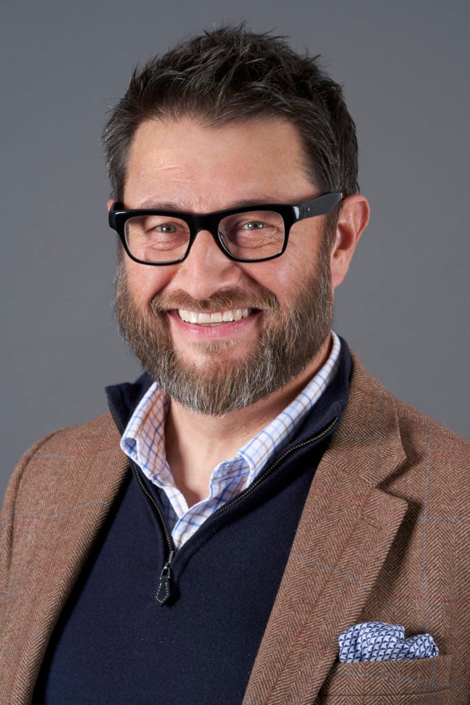 Professional studio headshot against a neutral background