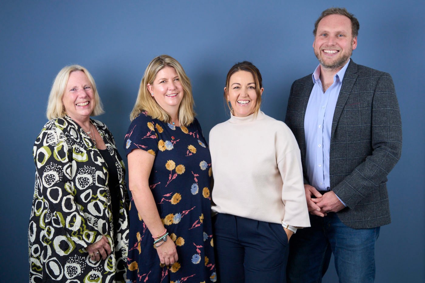 Group portrait of the Pebbles team against a blue backdrop