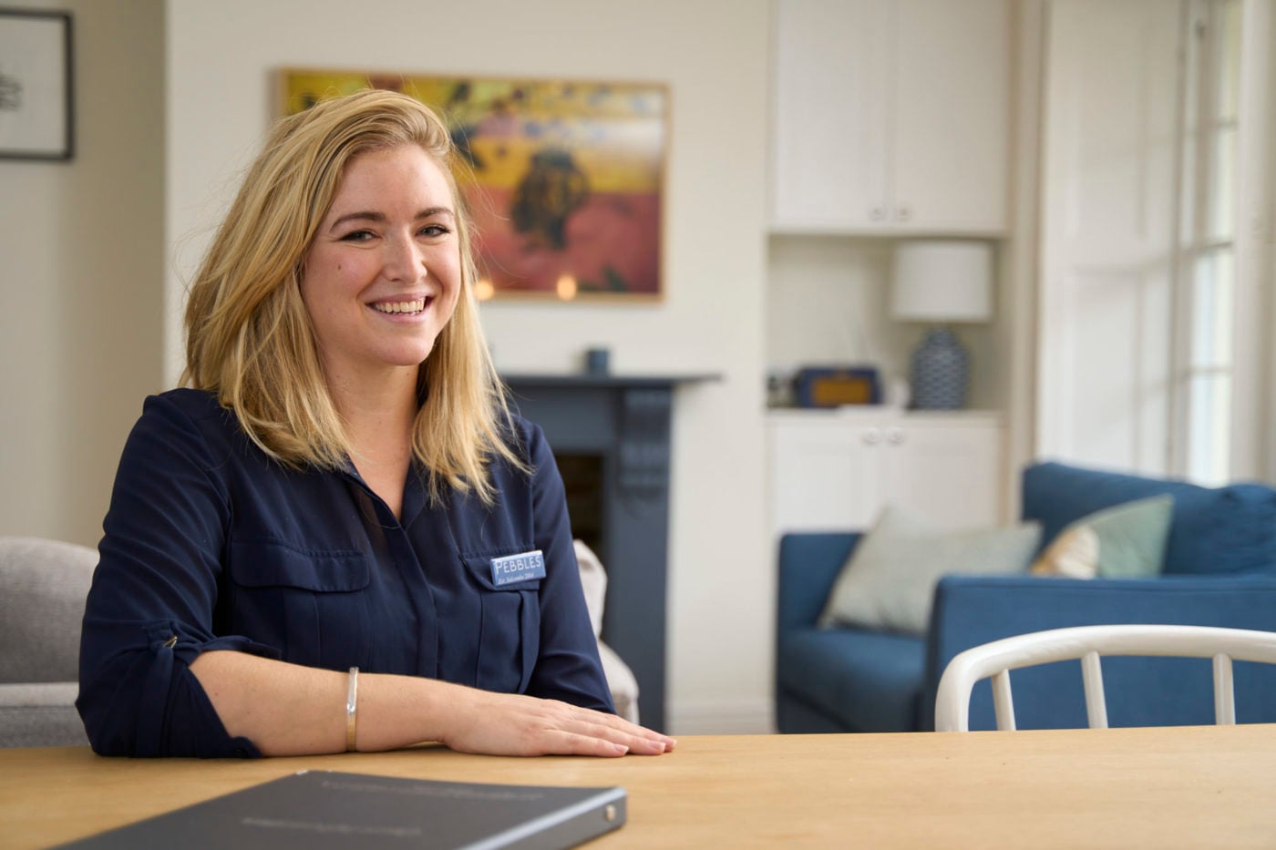 Portrait of a Pebbles team member seated at reception
