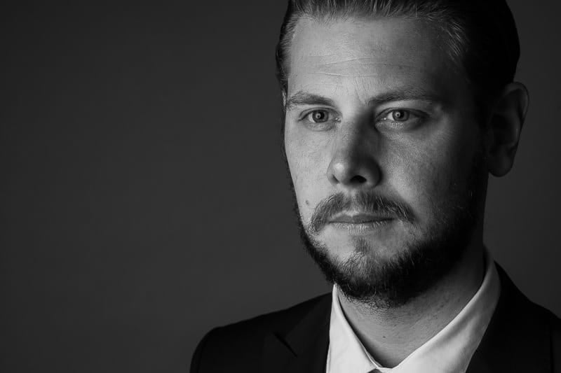 Professional headshot of a team member, dramatic lighting
